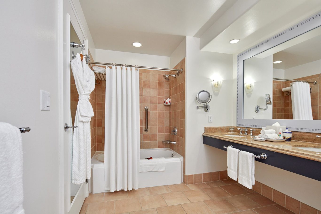 Modern bathroom with a bathtub, shower curtains, and a large mirror above the sink.