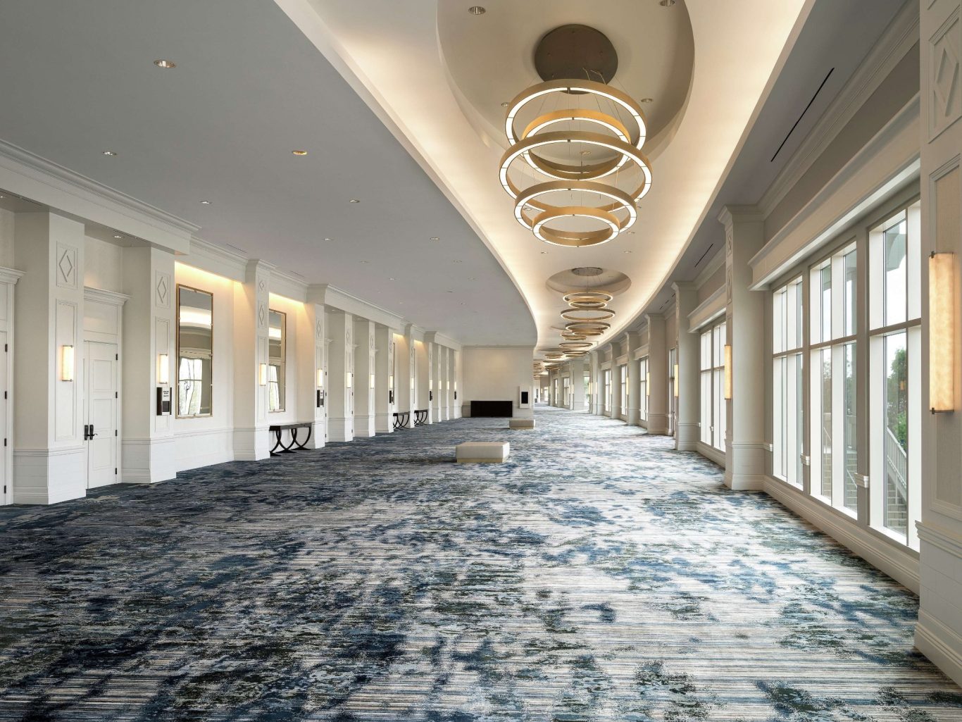 Stylish hallway featuring modern chandeliers and a patterned carpet.