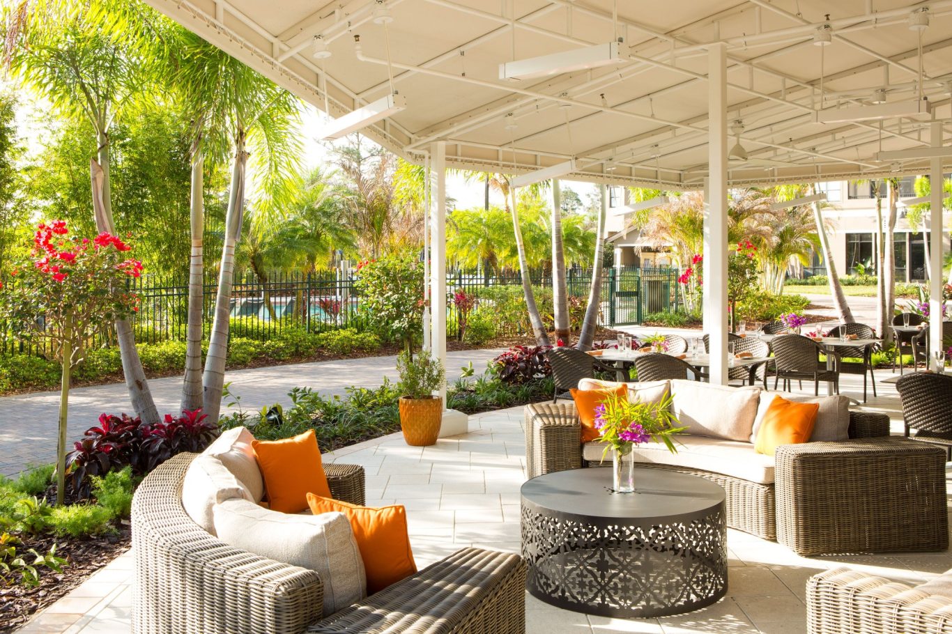 Stylish outdoor seating area with lush greenery and vibrant flowers.