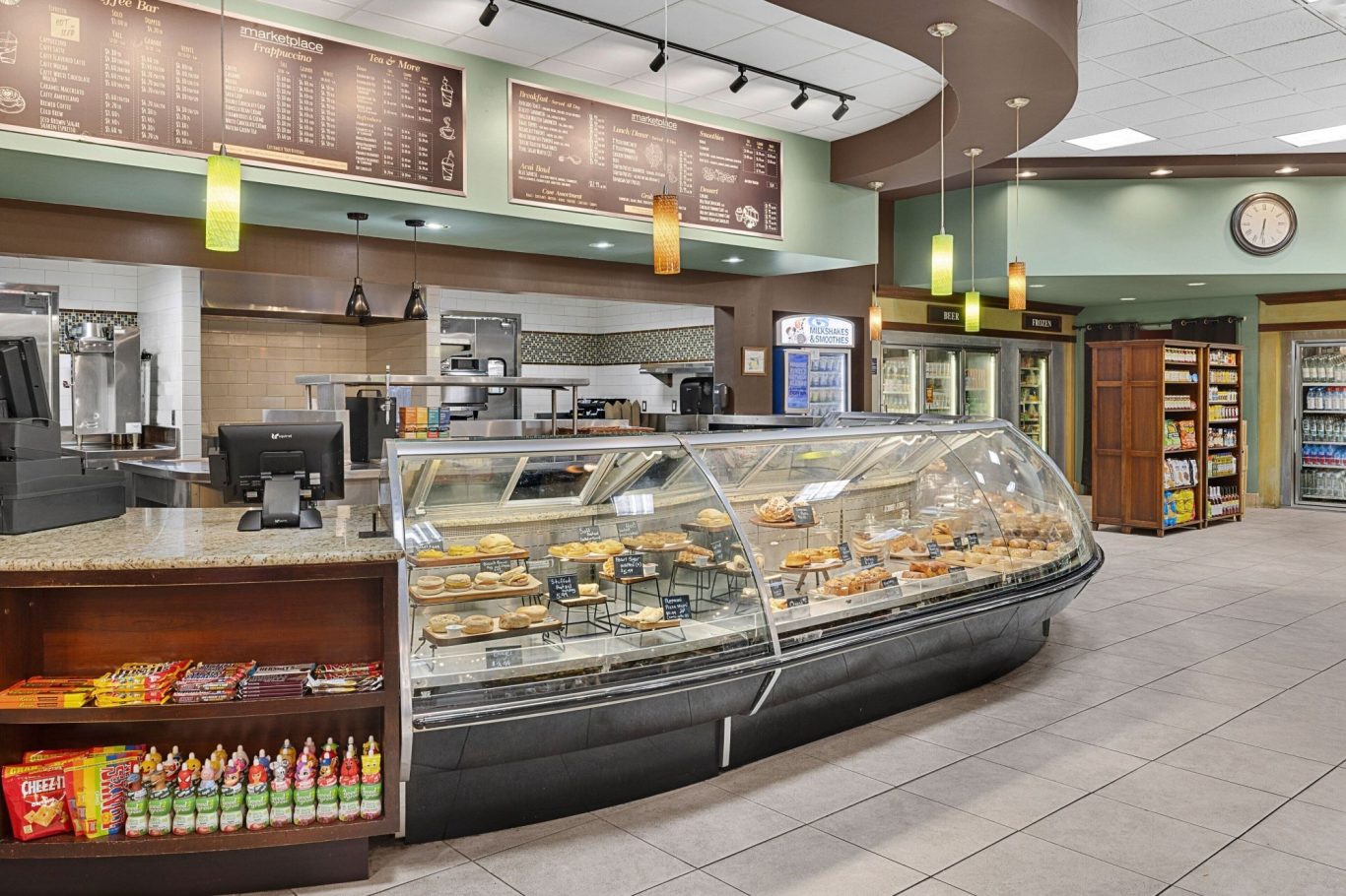 A modern café counter displaying a variety of pastries and snacks.