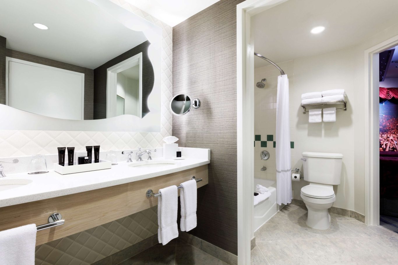 Modern bathroom with a shower, toilet, and a sink with toiletries on the counter.