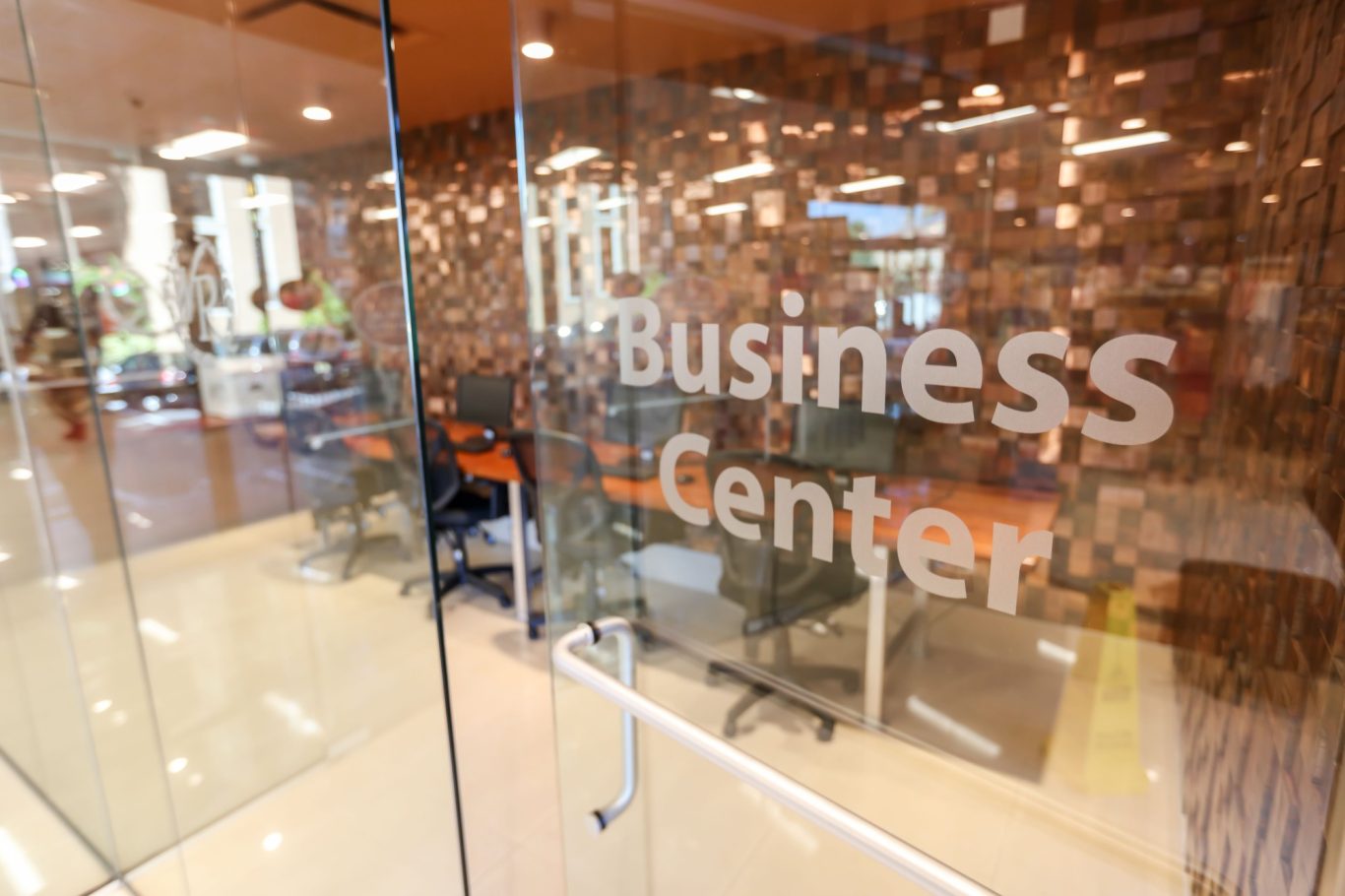 Doorway to a modern business centre with glass partitions and office furniture visible.