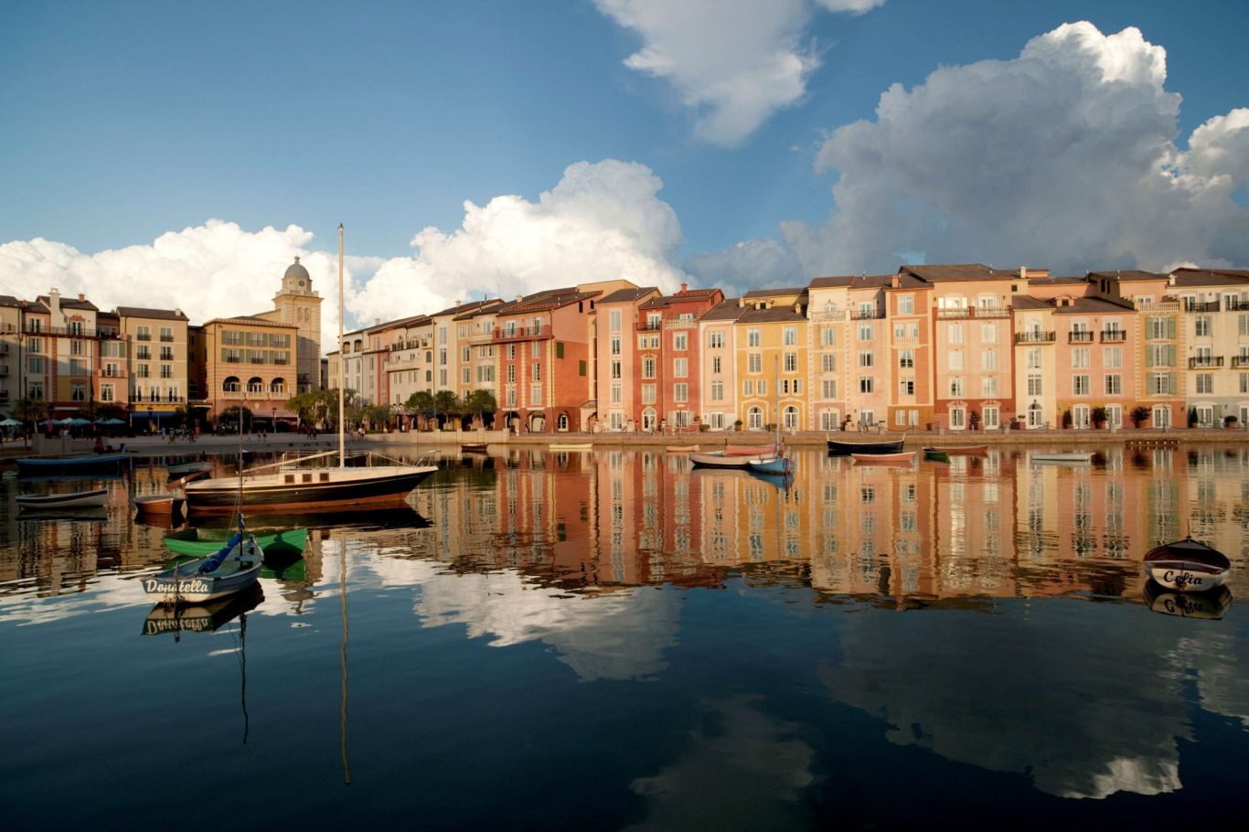 Vibrant waterfront scene featuring colourful buildings reflected in calm water.