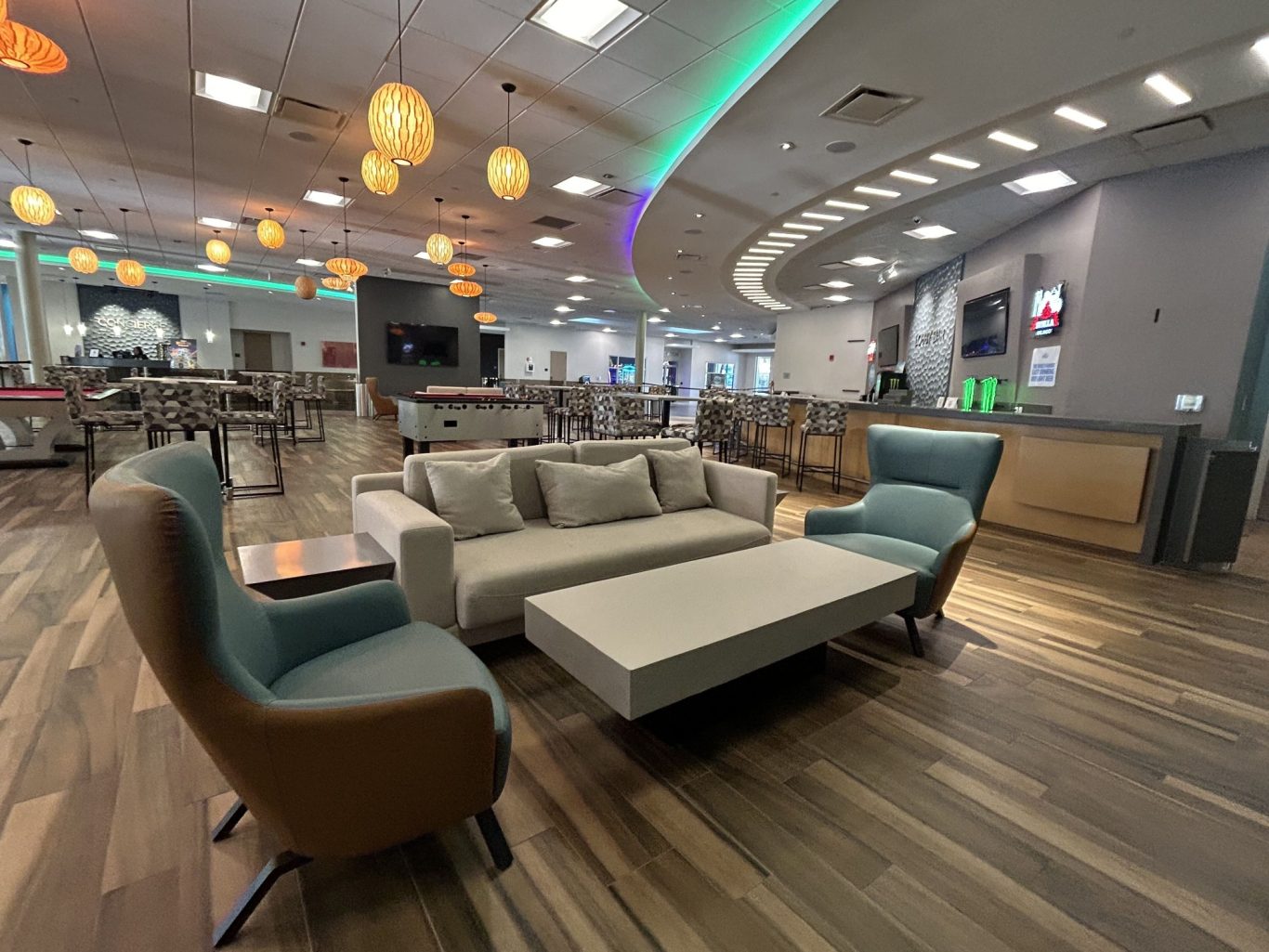 Modern lounge area with sofas, chairs, and soft lighting in a spacious setting.