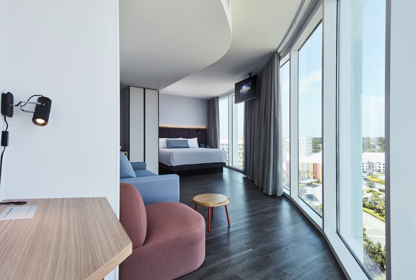 Modern hotel room with large windows, sleek furniture, and a bright, airy atmosphere.