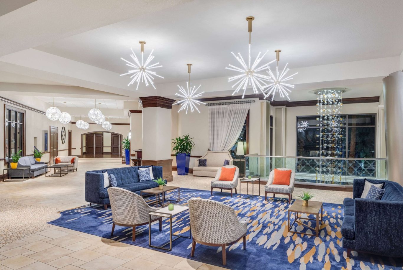 Modern hotel lobby with stylish seating, decorative lighting, and indoor greenery.