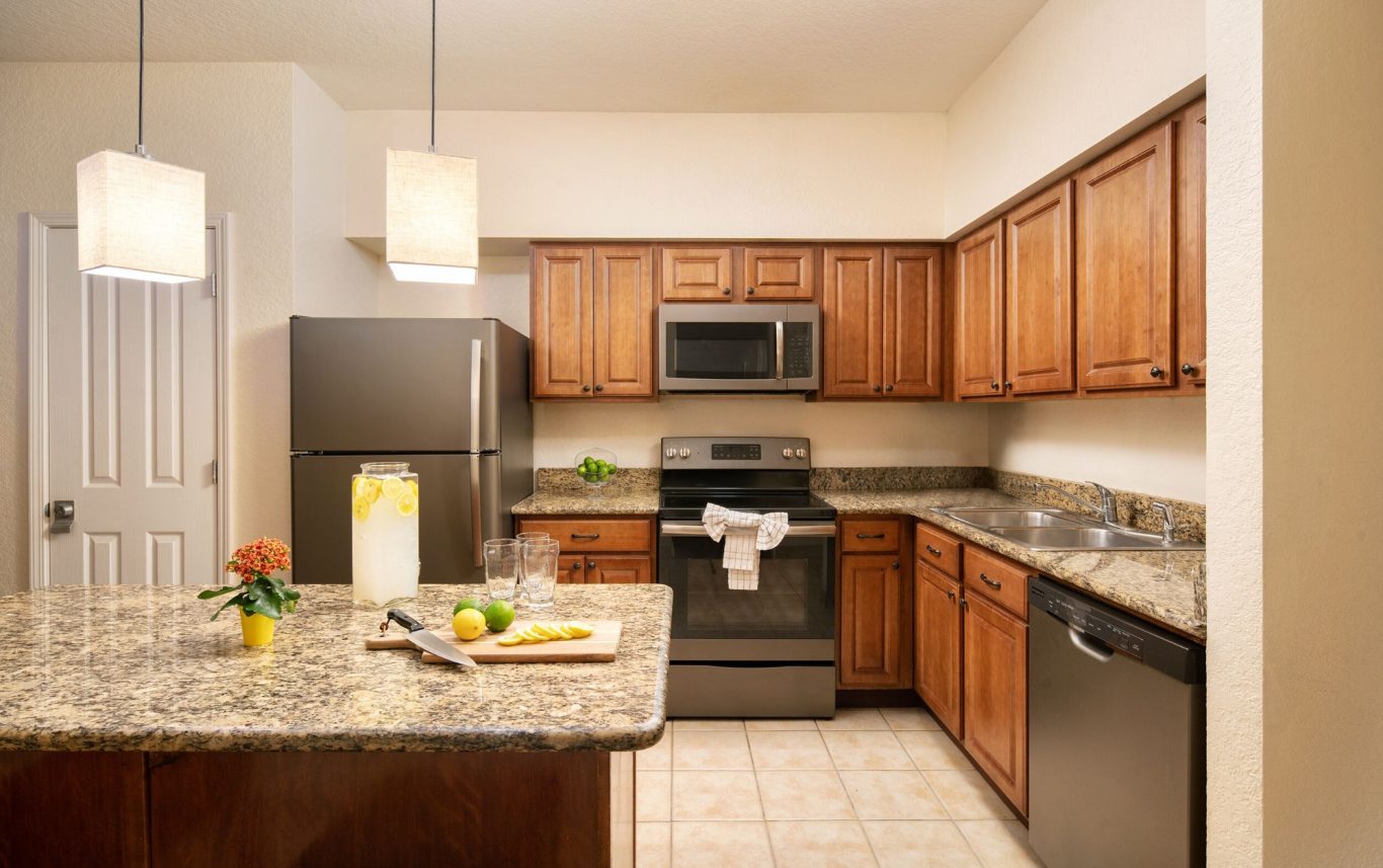 Modern kitchen featuring wooden cabinets, granite countertops, and stainless-steel appliances.