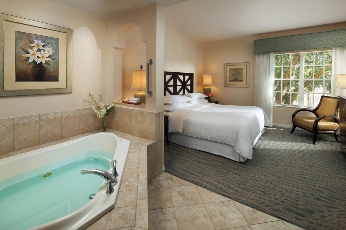 Luxurious hotel room with a king-size bed, seating area, and a private jacuzzi.