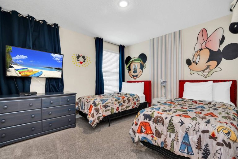 Child-friendly bedroom with Mickey and Minnie Mouse decor, two beds, and a TV.