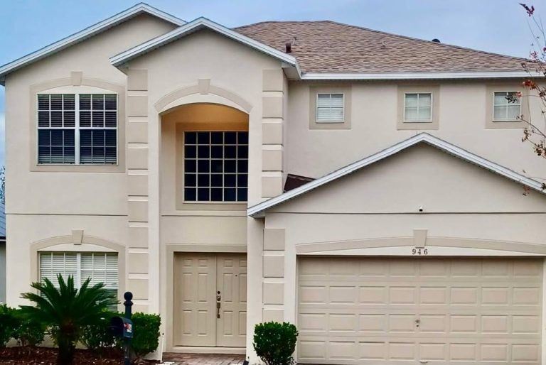 Two-storey suburban house with a large front porch and multiple windows.