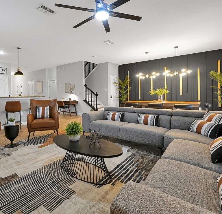 Modern living room featuring a sectional sofa, stylish lighting, and a decorative rug.