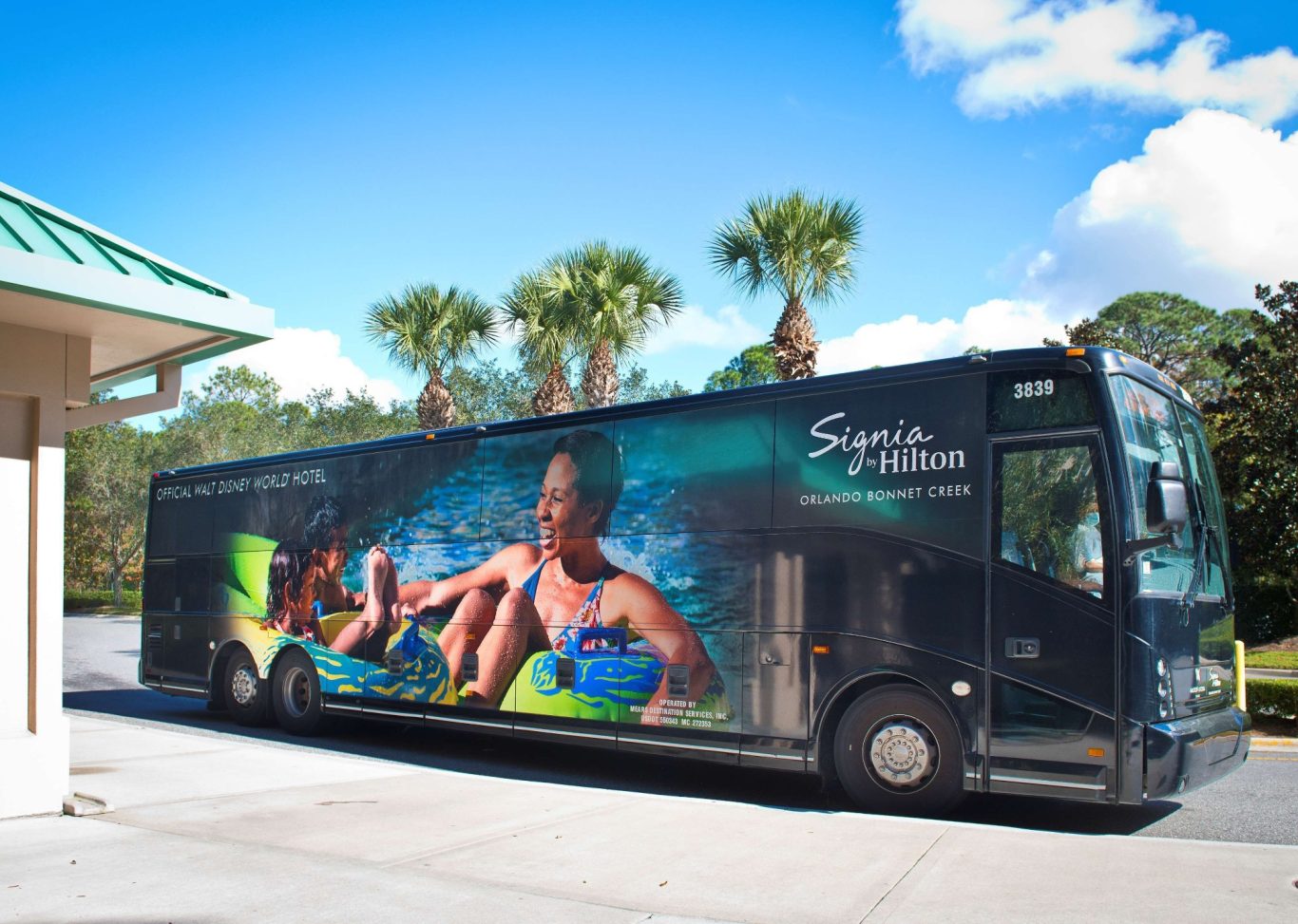 A bus with a promotional wrap featuring people enjoying water activities.