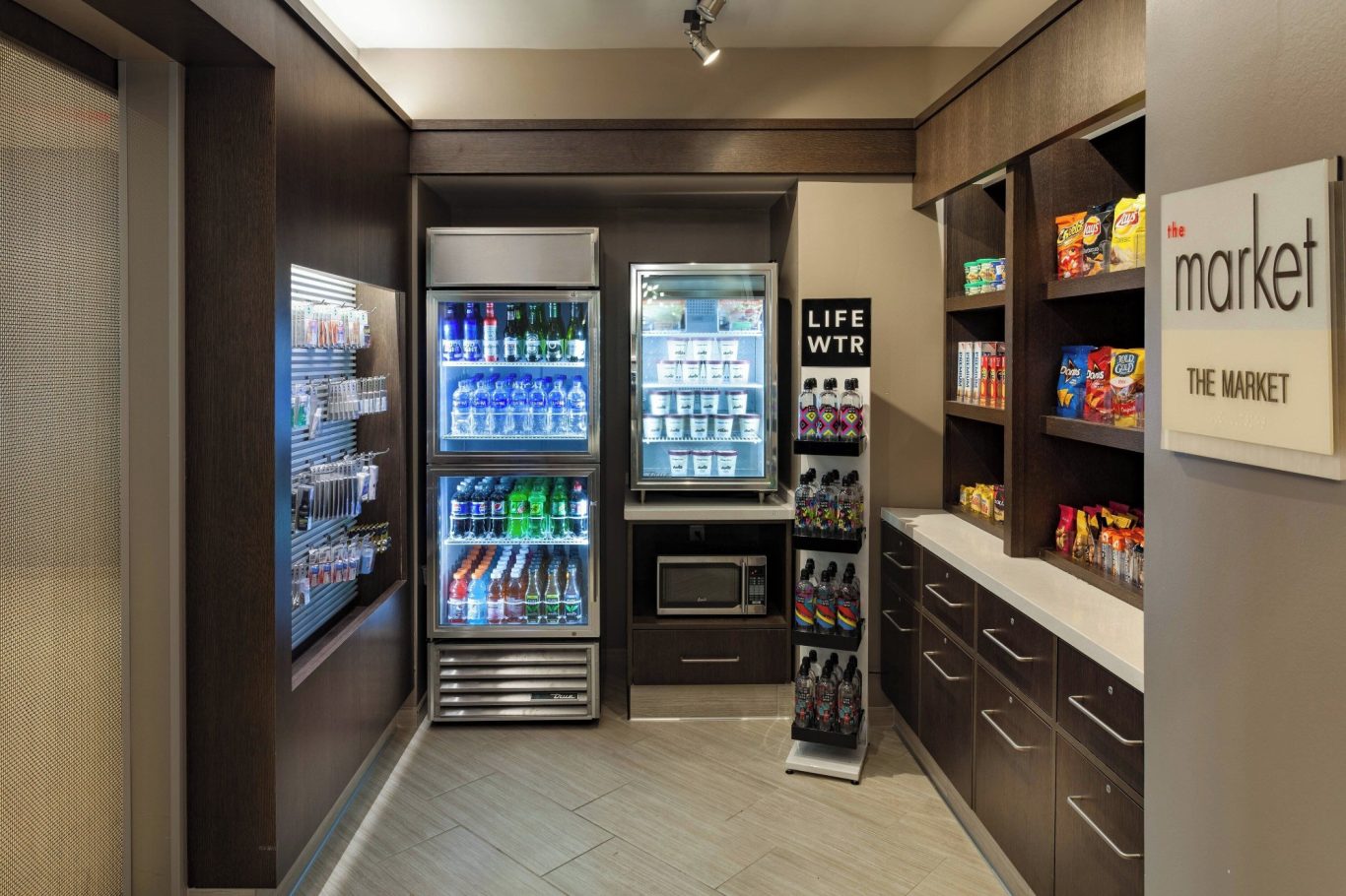 Modern vending area with snack shelves and beverage coolers in a stylish setting.