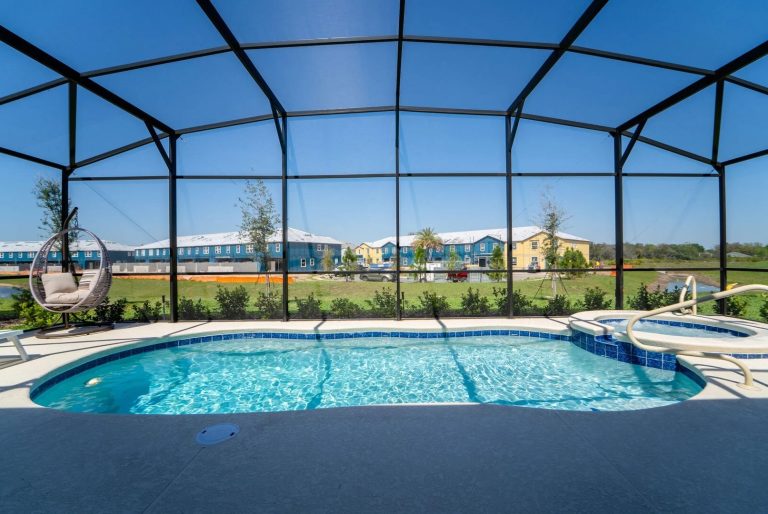 A clear blue pool with a screened enclosure and a view of landscaped gardens.