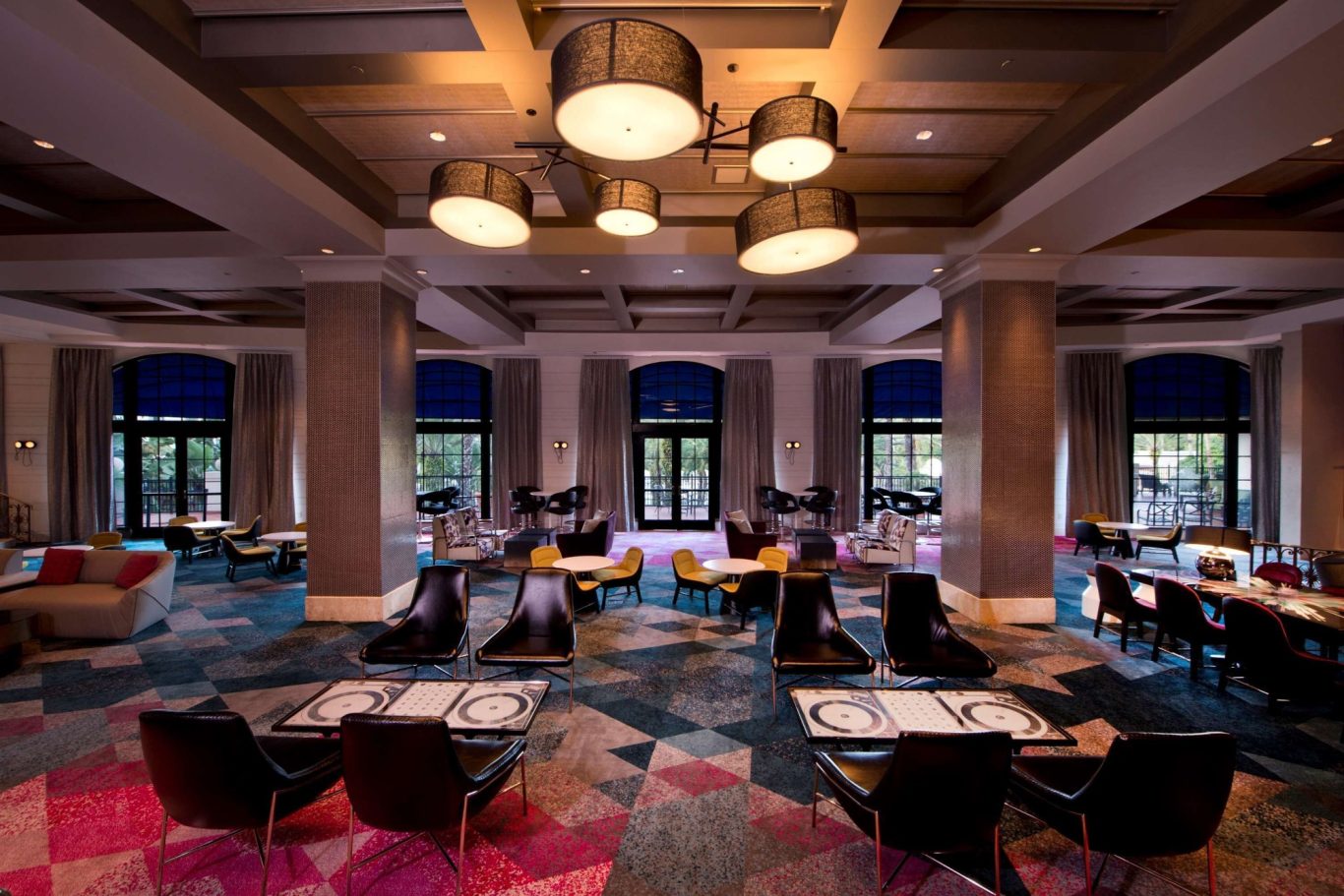 Modern restaurant interior with vibrant decor, stylish seating, and large windows.