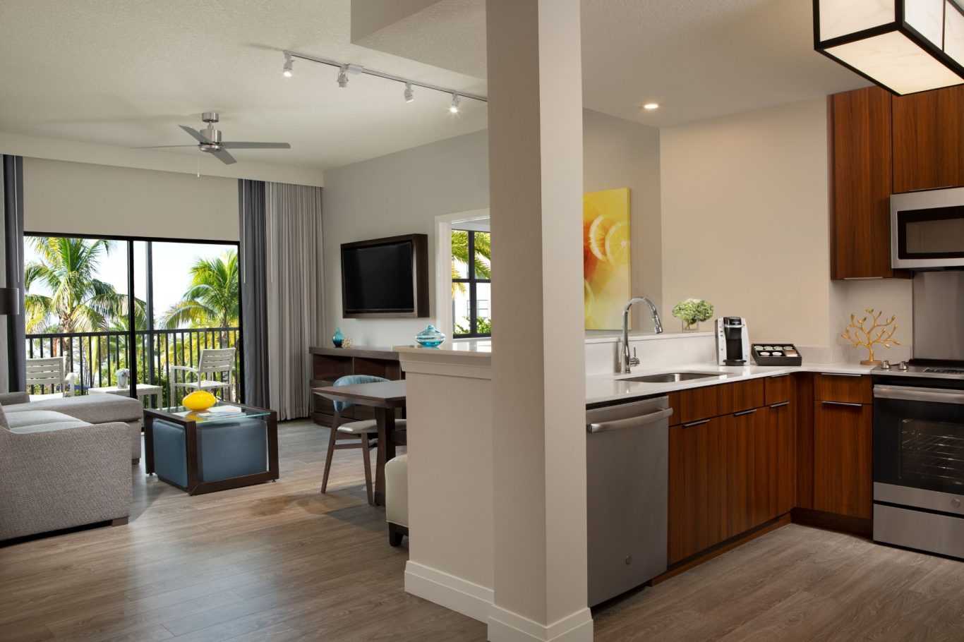 Modern kitchen and living area with large windows and tropical views.