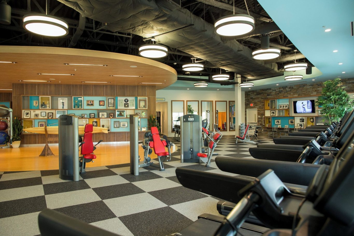 Modern gym interior featuring workout machines and a welcoming reception area.