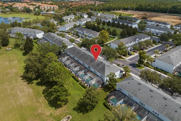 Aerial view of residential area with a location marker on a house.