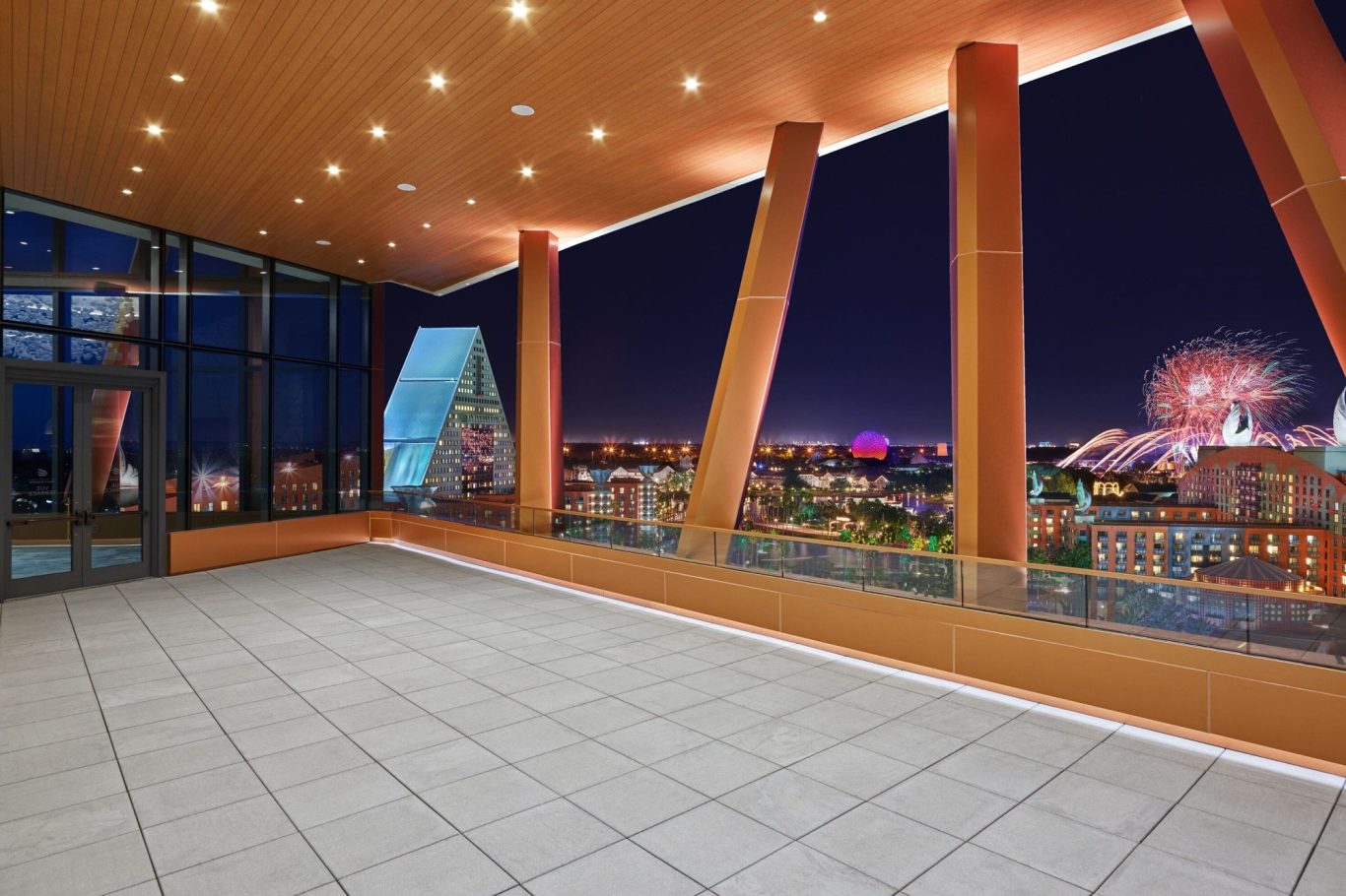 Modern interior with large windows offering a night view of a city skyline.
