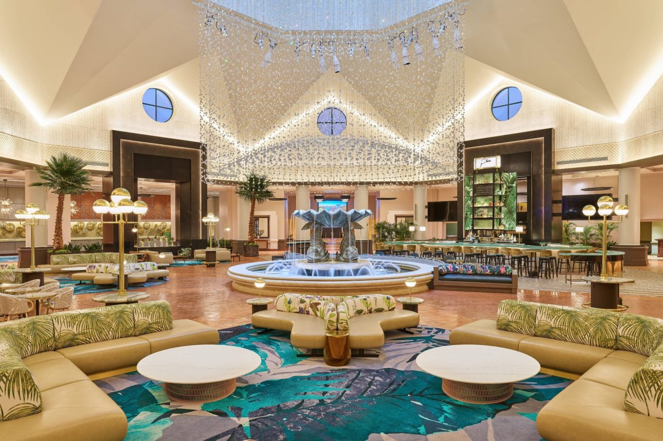Luxurious hotel lobby with elegant seating, chandelier, and water feature.