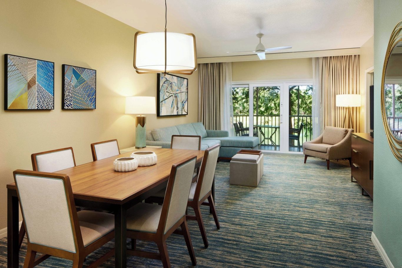 Bright living area with a dining table, modern furniture, and large windows.