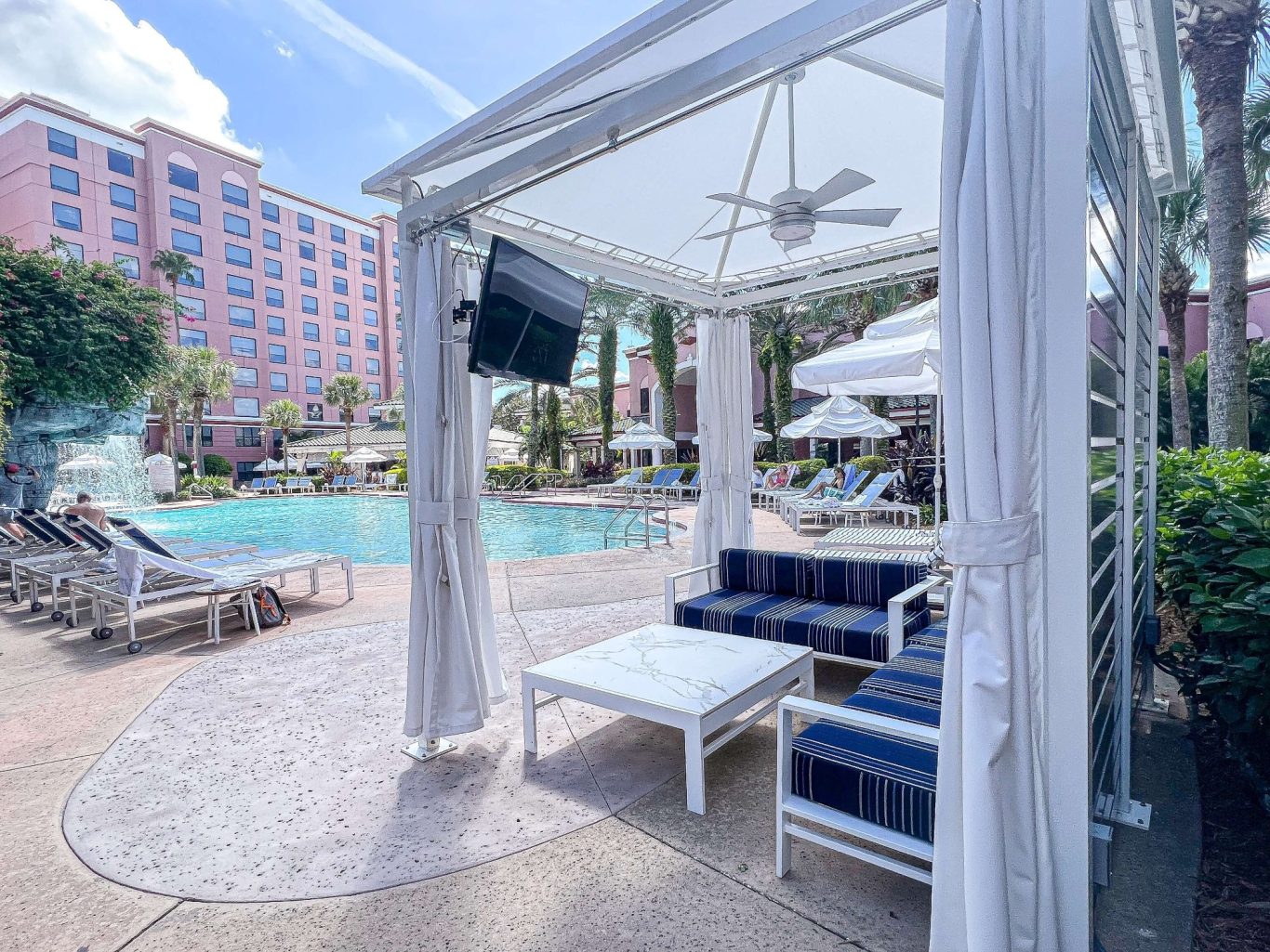 Poolside lounging area with a cabana, seating, and a view of the swimming pool.