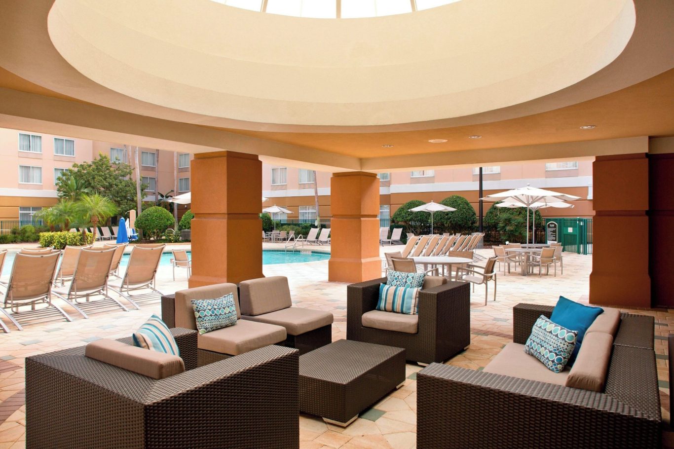 Stylish outdoor seating area with a view of a pool and sun loungers.