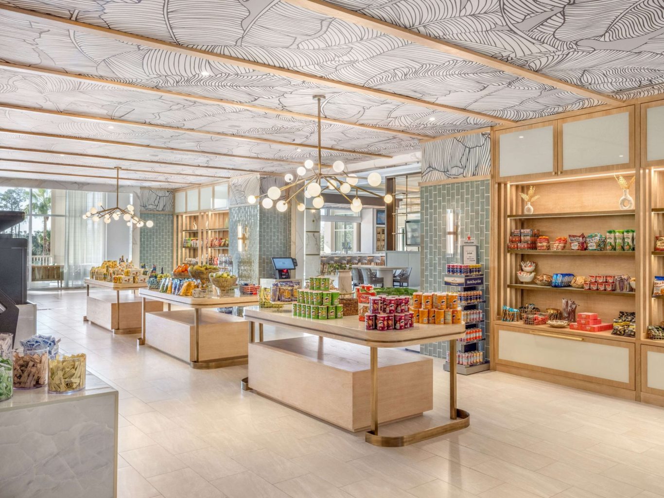 Brightly lit shop interior with shelved snacks and decorative ceiling.