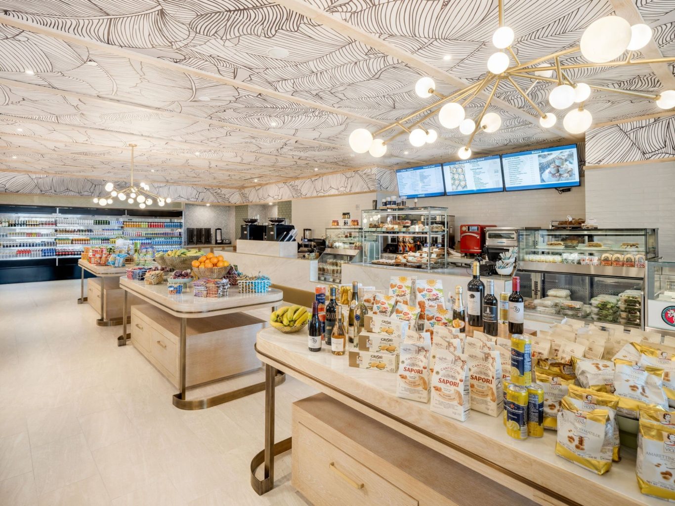 Bright café interior with display counters filled with food and drinks. Modern décor.