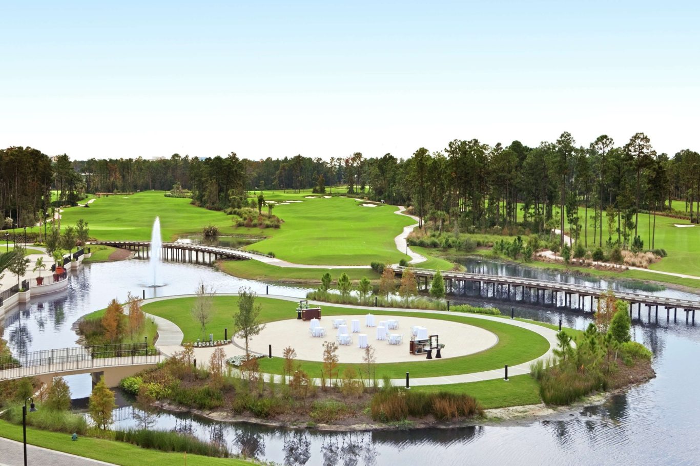 A scenic park featuring a pond, fountain, and landscaped green areas.
