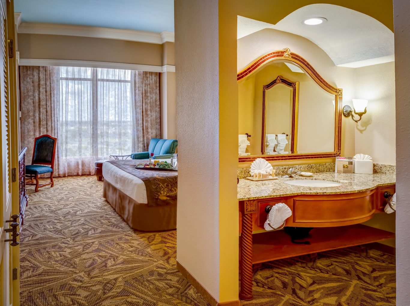 A spacious hotel room with a bed, seating area, and adjoining bathroom.