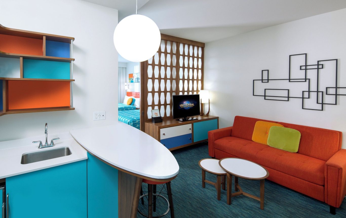 Modern living room with orange sofa, round tables, and stylish blue and orange decor.