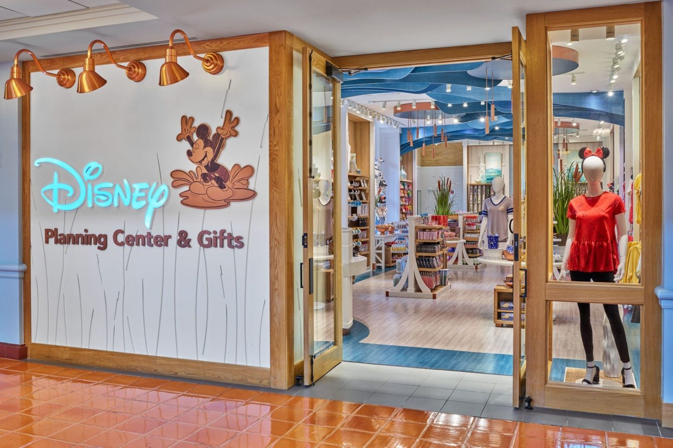 Entrance to a Disney store featuring merchandise and a mannequin in a red top.