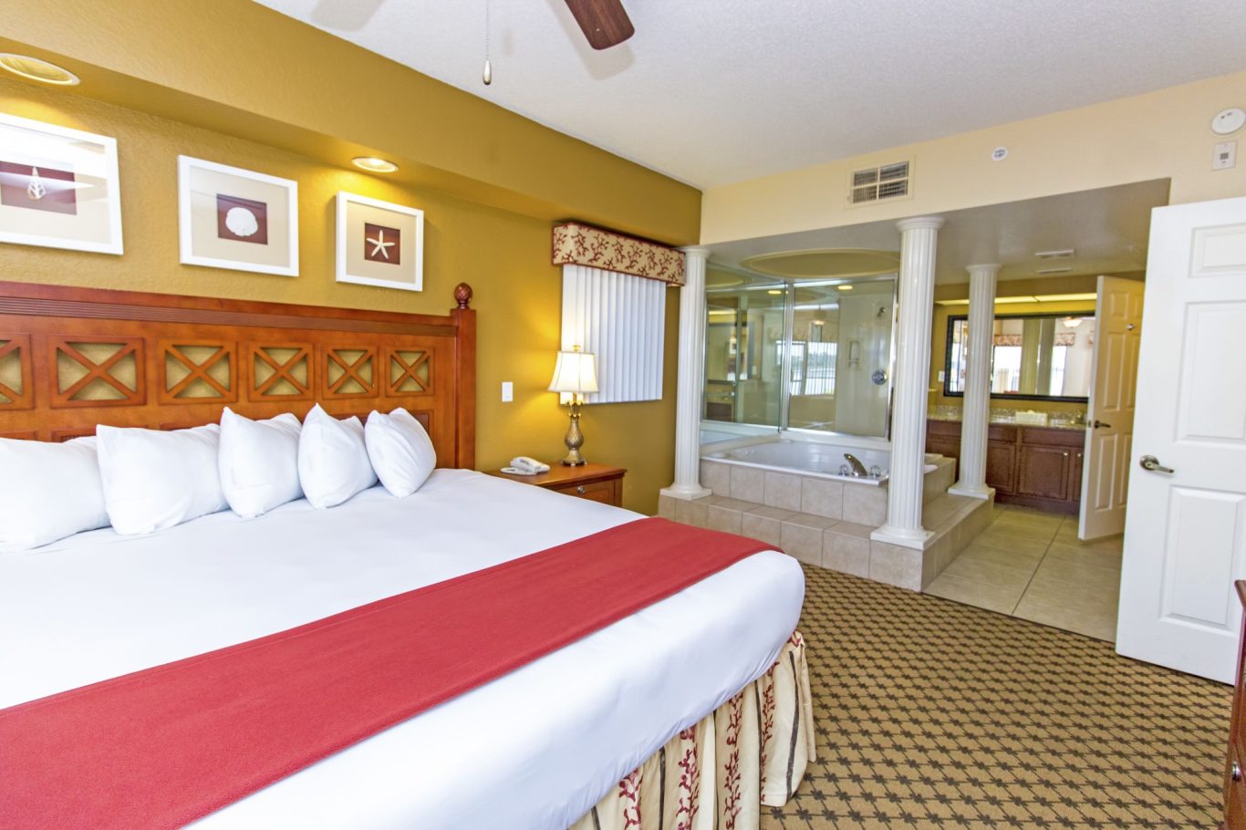 Hotel room with a king-sized bed and a spacious bathroom featuring a Jacuzzi.